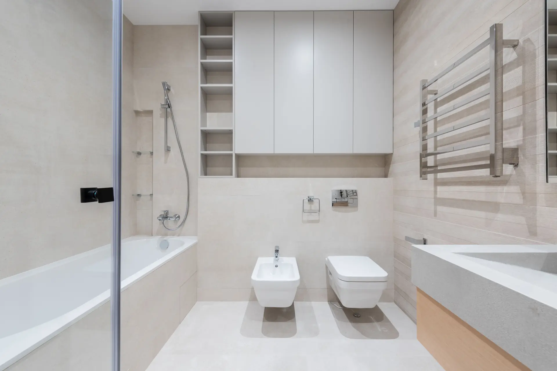 Calm bathroom with beige tiles, wall-hung closets and a washbasin